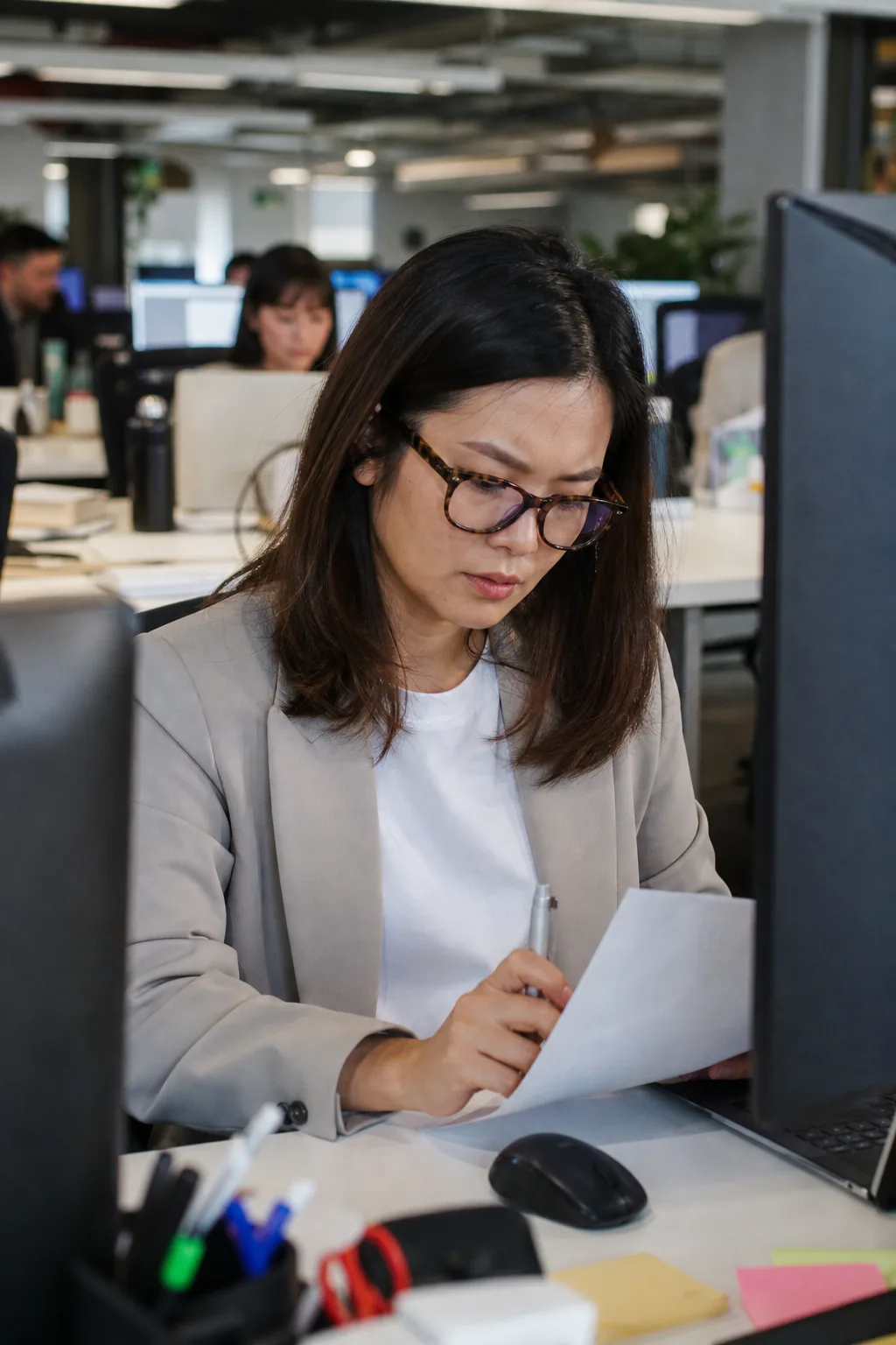 Female middle manager reviewing report with tortoiseshell glasses